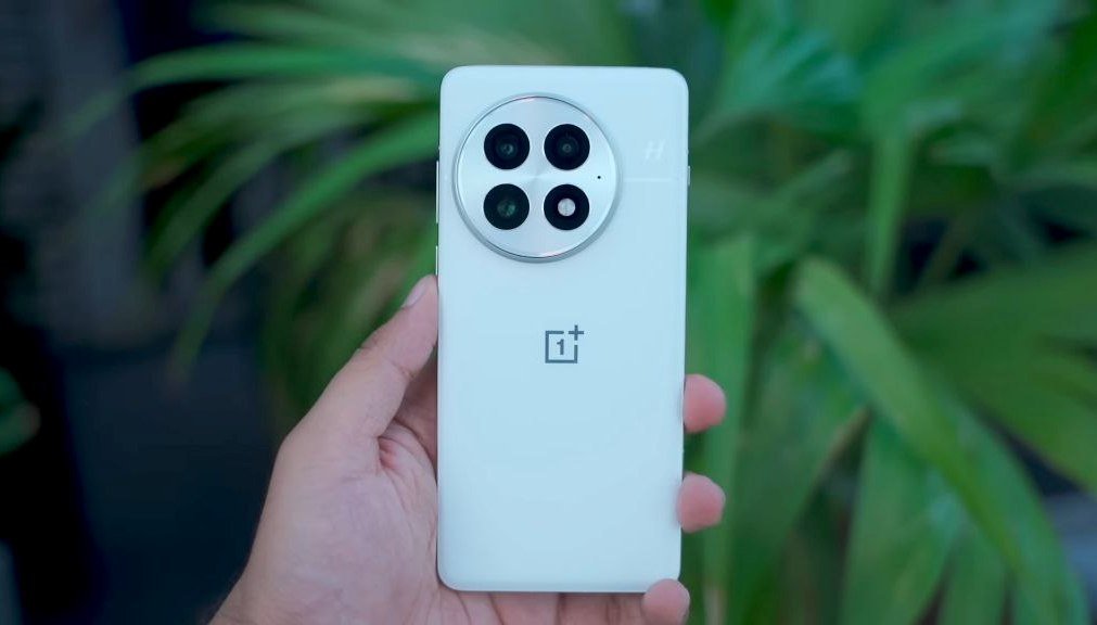 oneplus 13 a hand holding a white phone with four camera lenses